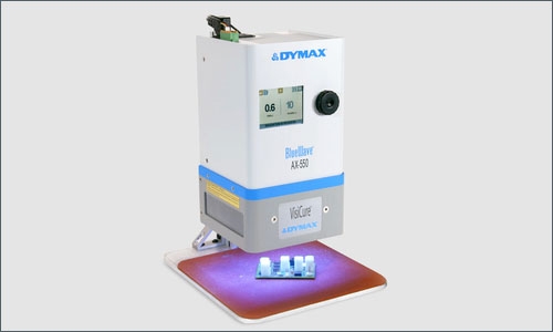 A Dymax BlueWave AX-550 flood lamp light cures an adhesive&nbsp;on a printed circuit board to secure components to it.