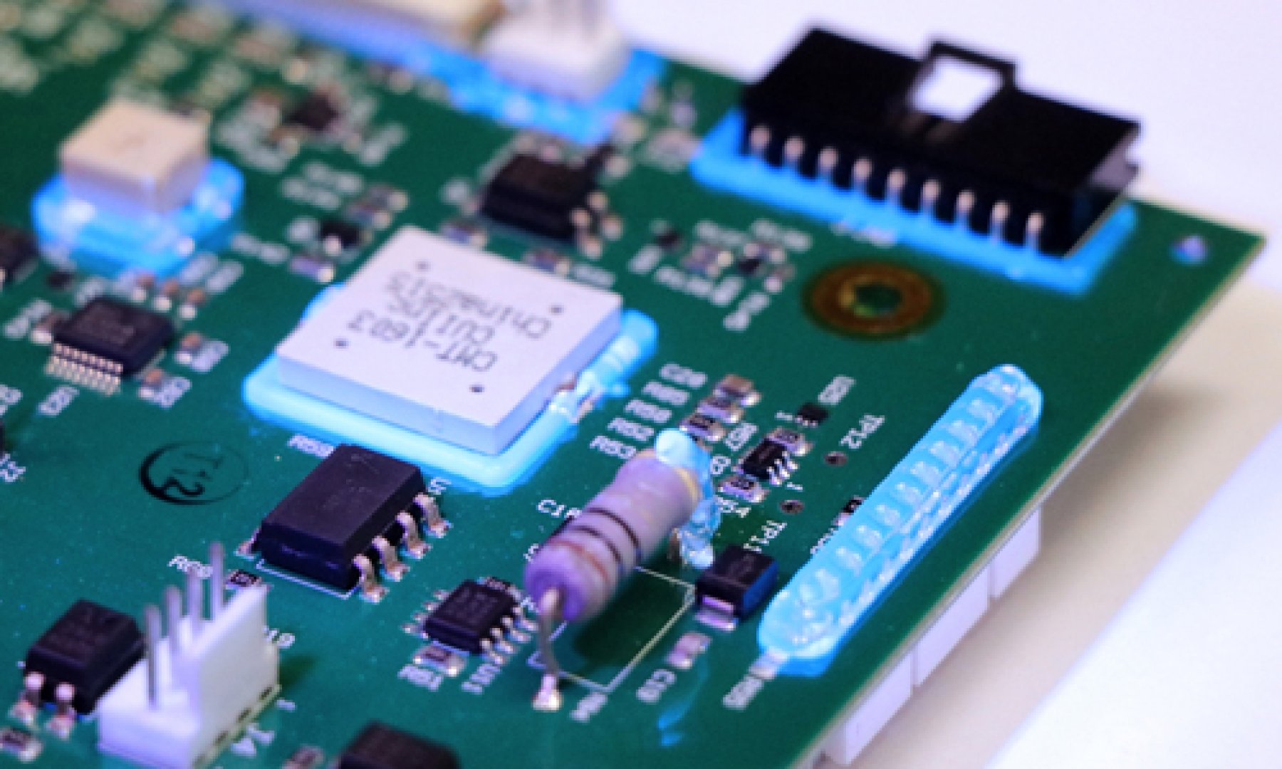A printed circuit board features Dymax fluorescing ruggedized adhesive for electronics assembly